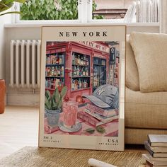 a new york city poster on the floor in front of a couch and bookshelf