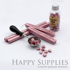 some pink candies are on a table next to a spoon and bottle with the word happy supplies