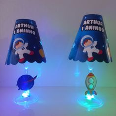 two lamps that are sitting on top of a table in the shape of rockets and astronauts