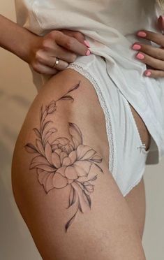 a woman with a flower tattoo on her thigh