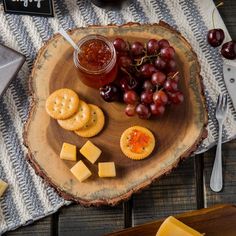 grapes, cheese and crackers on a wooden plate