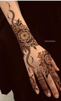 a woman's hand with henna tattoos on it