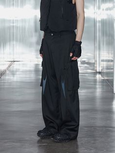 Experience a unique blend of sophistication and utility with the Embroidered Arrows Cargo Suit Pants. Crafted from premium suit fabric, these cargo pants redefine tradition with their cutting-edge design. Enhanced with creases on the pockets for added dimension and sleek arrow-like lines above the knee, the pants showcase a minimalistic yet futuristic appeal. Set in a pure black hue, these are where sartorial excellence meets modern-day innovation. Crafted from premium suit fabric for elevated s Arrow Embroidery, Elevated Style, Pure Black, Suit Fabric, Minimalistic Design, Suit Pants, Edge Design, Above The Knee, Male Model