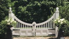 a white gate with flowers on each side