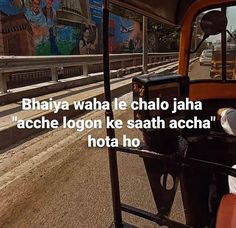 a man driving a bus down a street next to a train track with graffiti on the walls