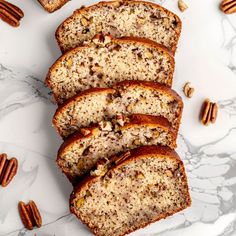 slices of pecan nut bread on a white plate with pecans around it and one slice cut off