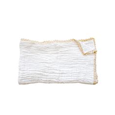 a white blanket with ruffles on it and a yellow trim around the edge