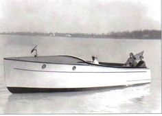 a white boat floating on top of a lake next to a bird flying over it