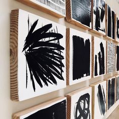 several black and white paintings hanging on the wall