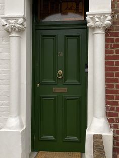 a green front door on a brick building