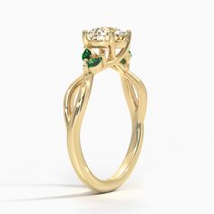 a yellow gold ring with two green stones on the top and bottom, set in 18k yellow gold