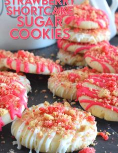 strawberry shortcake sugar cookies with white frosting and sprinkles on top