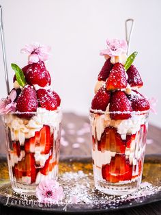 two dessert cups with strawberries and whipped cream