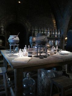 an old fashioned kitchen with many bottles on the table and cooking utensils in front of it