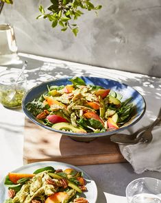 two plates of food on a table with glasses and utensils in the background