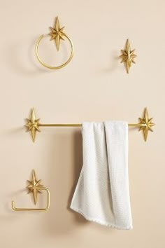 three gold stars hang on the wall next to two towels and a towel rack with hooks