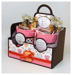 a pink gift basket with coffee mugs and candies