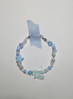 a bracelet with blue and white beads, silver charms and a fish charm on it