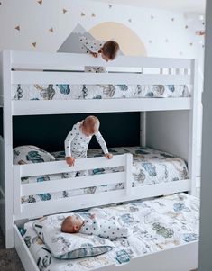 two toddlers playing on the bottom bunk of a white bunk bed in a bedroom