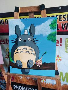 a painting of a totoro sitting on top of a tree branch in front of posters