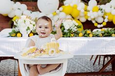 a baby sitting in a highchair with cake on it's face and hands