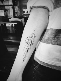 a woman's arm with an arrow tattoo on the left side of her arm