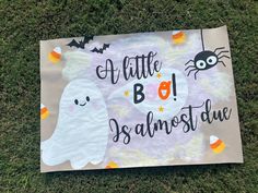 a sign that says, little boo is almost ghost due on the grass in front of some halloween decorations