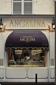 the front of an ice cream shop with awnings and lights on it's windows