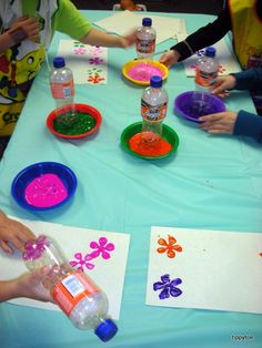 children are sitting at a table making crafts