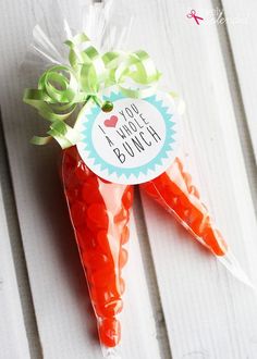 a carrot shaped candy bar sitting on top of a white wooden table next to a sticker