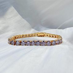 💎 5mm 18k Gold Plated Purple Moissanite Bracelet 💎 Certified VVS1 Moissanite: Meticulously selected stones for superior clarity and vibrant purple hue, akin to natural diamonds. 🌟 Made with 925 Sterling Silver & Triple-layer 18k Gold Plating: Provides a durable, lustrous finish that enhances the bracelet's luxurious appeal. ⚖️ Tennis Bracelet Design: Classic and versatile, suitable for everyday wear or as a statement piece for special occasions. 🎁 Perfect Gift: Ideal for both men and women w Purple Luxury Tennis Bracelet, Gold Round Moissanite Diamond Bracelet, Gold Moissanite Diamond Bracelet, Gold Moissanite Diamond Bracelet With Brilliant Cut, Jubilee Moissanite Bracelets, Jubilee Bracelet In Moissanite, Moissanite Jubilee Bracelet As Gift, Diamond White Gold Bracelet With Prong Setting Gift, Gold Moissanite Jubilee Diamond Bracelet