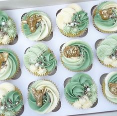 twelve cupcakes decorated with green and white frosting, gold decorations and pearls