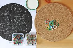 a cork board with various crafting supplies on it and a star chart in the background