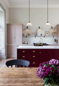 a kitchen with purple flowers on the table