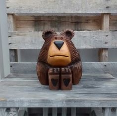 a carved bear sitting on top of a wooden bench