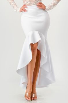 a woman wearing a white dress with long sleeves and a high low skirt, posing for the camera