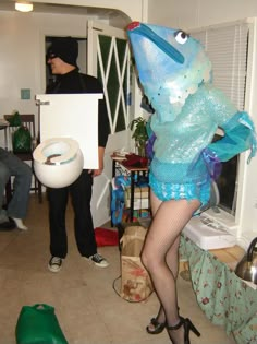 a woman dressed as a fish holding a sign in her hand and standing next to a man