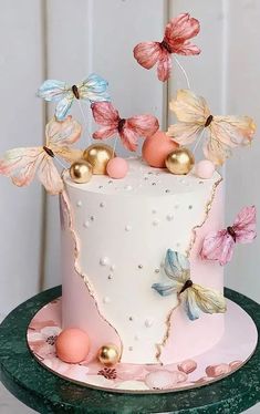 there is a white cake with butterflies on it