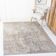 an area rug with a chair in front of it and a painting on the wall