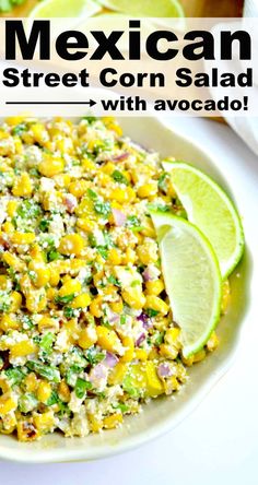 mexican street corn salad with avocado in a white bowl and lime wedges on the side