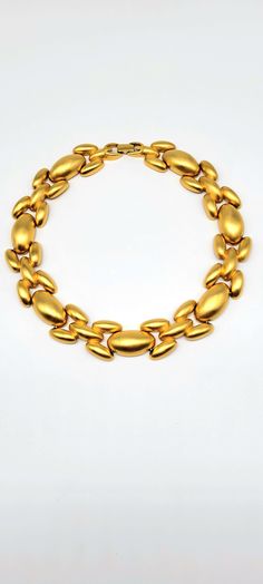 "Brushed Gold Necklace, Matte Gold Choker, Chunky Collar Necklace, Satin Finish Necklace, Vintage Givenchy Necklace, Stiff Necklace Measurements: 15\" Metal: Gold Tone Findings: Signature Givenchy Fold Over Clasp Finish: Matte, Satin, Brushed EXCELLENT CONDITION After a while all plain gold statement necklaces start to look the same, that's why I am only interested in UNIQUE gold statement pieces. Take this vintage STUNNER from French elite fashion company Givenchy! What makes this piece unique? Let's start with the BREATHTAKING gold finish. Unlike most pieces that are polished, this necklace has a matte satin brushed gold finish! This finish makes the necklace have an AMAZING glow, almost as if the entire necklace is lit from within. The links themselves are also interesting, a mixture be Luxury Classic Necklaces In Recycled Gold, Luxury Elegant Yellow Gold Choker, Givenchy Necklace, Necklace Measurements, Elite Fashion, Vintage Givenchy, Gold Statement Necklace, Gold Choker, Matte Satin