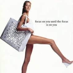 a woman is holding a shopping bag and posing with her legs spread out in the air