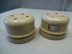 two ceramic salt and pepper shakers sitting on a white tablecloth covered counter top