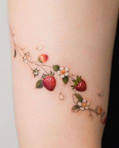 a woman's thigh with flowers and strawberries on it