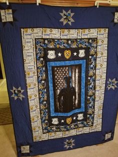 a blue and black quilt with a man in the center surrounded by stars on it