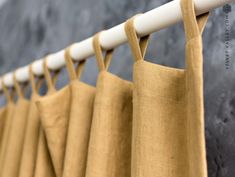 tan linen curtains hanging on a white rod