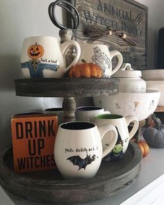 halloween mugs are stacked on top of each other in front of a sign that says drink up witches