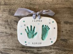 a baby's hand and foot print on a ceramic plaque