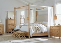 a bedroom with white walls and wooden furniture