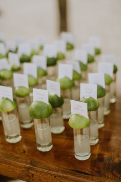 small glasses filled with green fruit on top of a wooden table